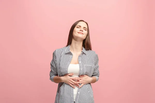 A mulher de negócios feliz de pé e sorrindo contra fundo rosa . — Fotografia de Stock