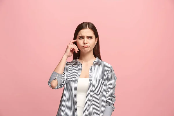 Let me think. Doubtful pensive woman with thoughtful expression making choice against pink background