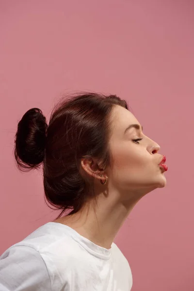 Ritratto di attraente ragazza carina con trucco luminoso con bacio isolato su sfondo rosa — Foto Stock