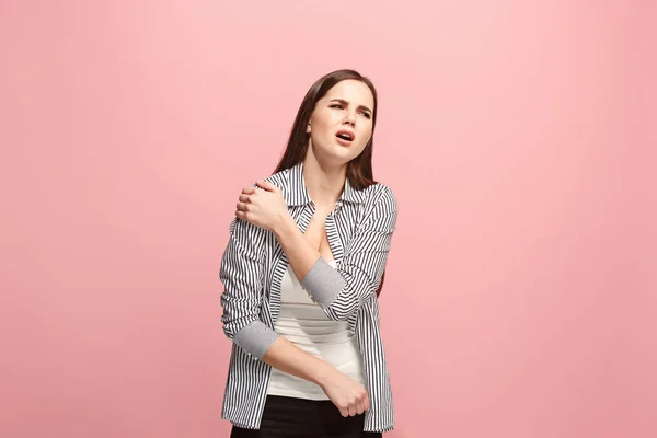 A dor de ombro. A mulher triste com dor no ombro ou dor em um fundo de estúdio rosa . — Fotografia de Stock