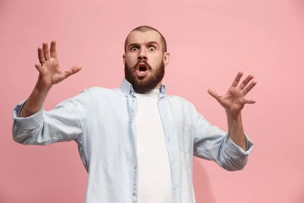 Der junge attraktive Mann sieht überrascht isoliert auf rosa — Stockfoto