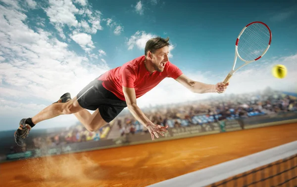 O jogador que salta, homem em forma caucasiano, a jogar ténis na quadra de barro com espectadores — Fotografia de Stock