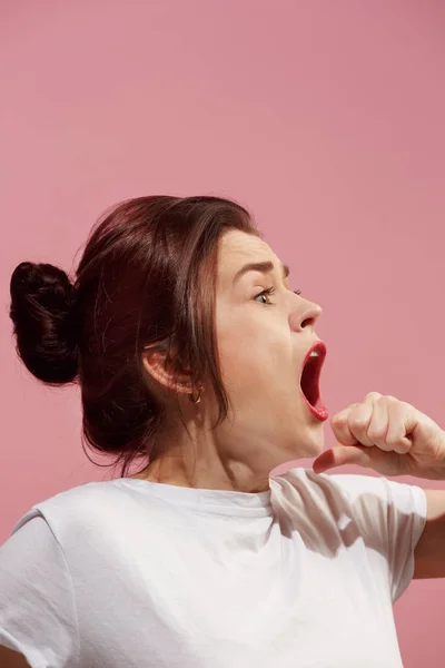 Mladá emocionální naštvaná žena křičí na růžové studio pozadí — Stock fotografie