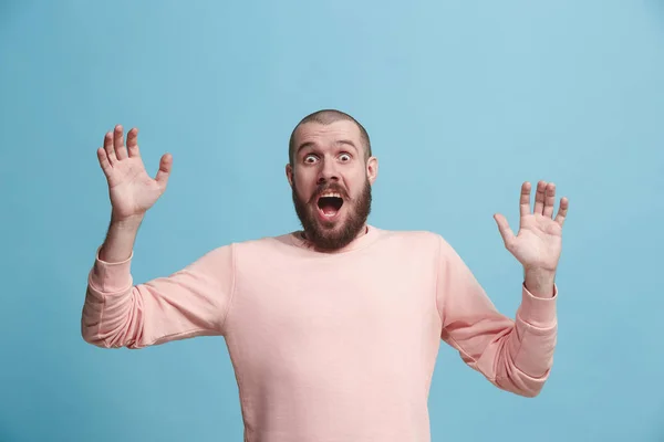 O jovem atraente homem olhando suprised isolado em azul — Fotografia de Stock