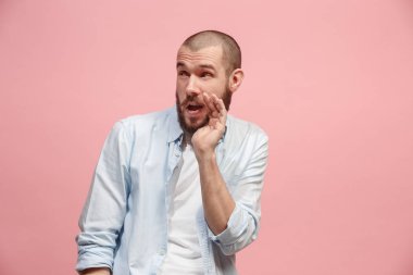 Pembe arka plan üzerinde elini arkasındaki sır fısıldayan genç adam