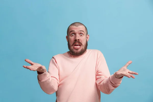 Belo retrato masculino de meia-duração isolado em backgroud estúdio azul. O jovem emotivo surpreendido homem — Fotografia de Stock