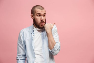 Pembe arka plan üzerinde elini arkasındaki sır fısıldayan genç adam