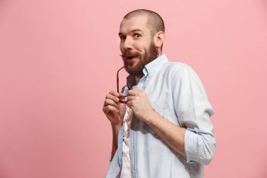 Pembe arka plan üzerinde elini arkasındaki sır fısıldayan genç adam