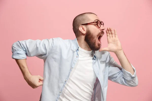 Isoliert auf rosa jungen lässigen Mann schreit im Studio — Stockfoto