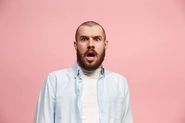 Il giovane uomo attraente che sembra sorpreso isolato sul rosa — Foto Stock