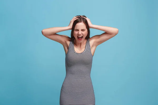 La joven mujer enojada emocional gritando en el fondo del estudio azul —  Fotos de Stock