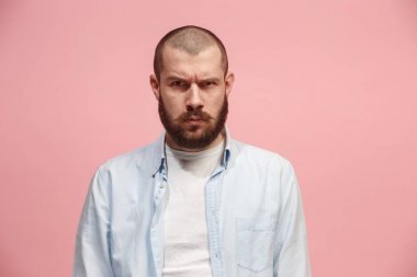 Ayakta ve kamera pembe bir arka plan karşı bakarak ciddi iş adamı.
