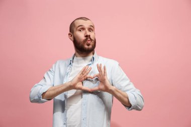 Pembe arka plan üzerinde izole öpücük ile çekici bir adam portresi