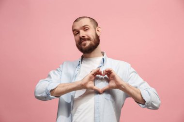 Pembe arka plan üzerinde izole öpücük ile çekici bir adam portresi