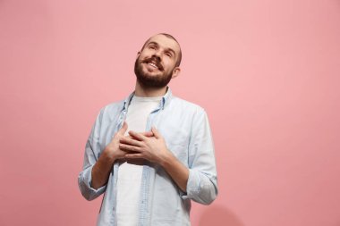 Ayakta ve pembe bir arka plan karşı gülümseyen mutlu işadamı.