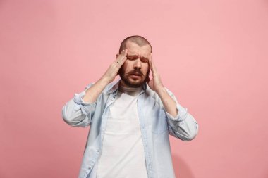 Baş ağrısı olan adam. Pembe arka plan üzerinde izole.