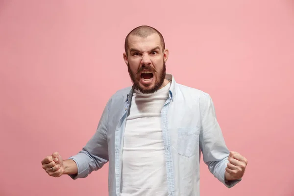 El joven hombre enojado emocional gritando en el fondo del estudio rosa — Foto de Stock