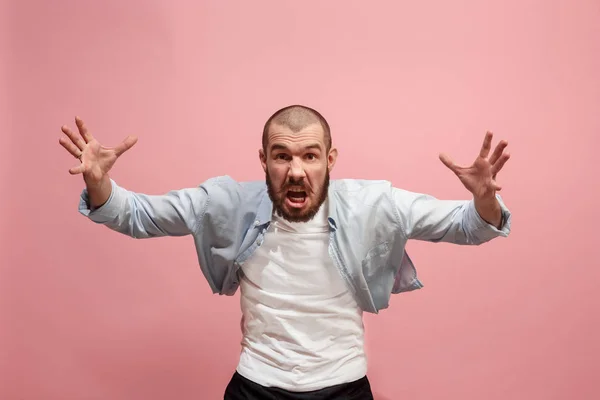 El joven hombre enojado emocional gritando en el fondo del estudio rosa — Foto de Stock