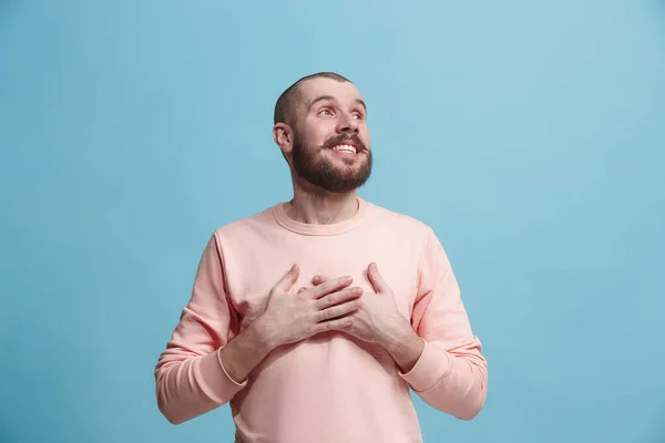 El hombre de negocios feliz de pie y sonriendo contra el fondo azul . — Foto de Stock