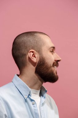 Pembe genç casual adam stüdyoda gülümseyen izole