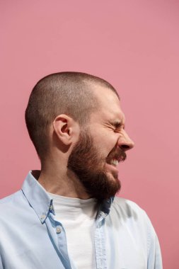 Pink izole stüdyoda genç casual adam korkuyor