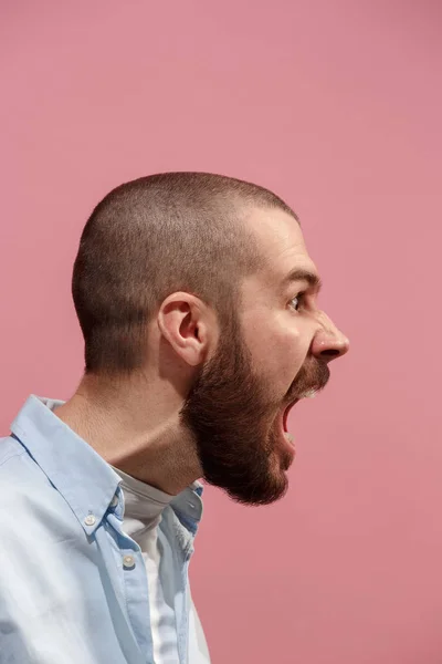 O jovem homem irritado emocional gritando no fundo do estúdio rosa — Fotografia de Stock