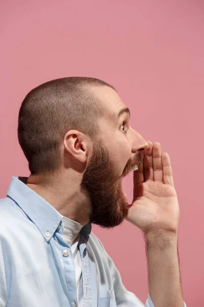 Isoliert auf rosa jungen lässigen Mann schreit im Studio — Stockfoto