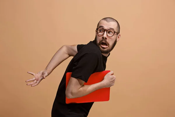 Retrato do homem assustado com o computador portátil no pastel — Fotografia de Stock