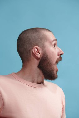 Şaşırmış görünen çekici adam izole mavi genç