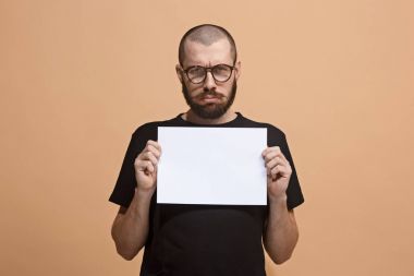 Genç bir adam boş bir levha, metin doldurmak için elinde tutar. Duygusal, cesur yüzü.