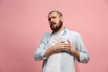 Kalp ağrısı olan adam. Pembe arka plan üzerinde izole.