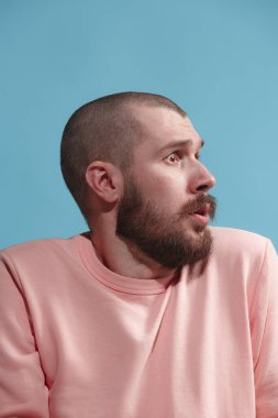 Mavi izole stüdyoda genç casual adam korkuyor