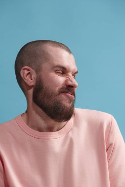 Mavi izole bir şey geçirmeyen tiksinti ifadesi ile genç adam