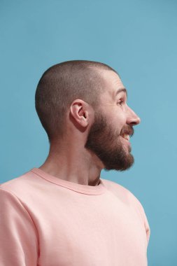 Gülümseyen ve stüdyoda zevk mavi genç casual adam izole