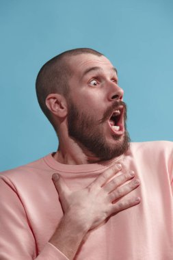 Mavi izole stüdyoda genç casual adam korkuyor