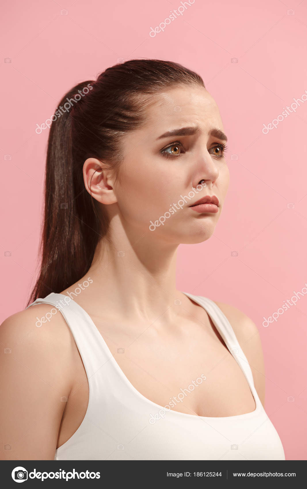 The young woman is looking sad on the pink background. Stock Photo by  ©vova130555@gmail.com 186125244