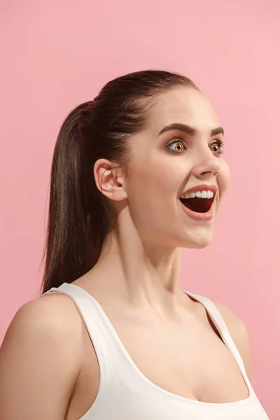 A mulher feliz de pé e sorrindo contra o fundo rosa . — Fotografia de Stock