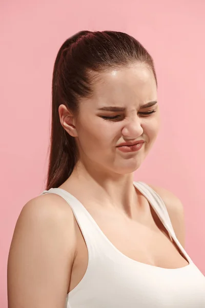 Mladá žena s znechuceným výrazem odstrčil něco izolovaných na růžové — Stock fotografie