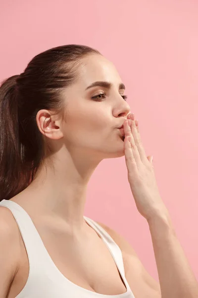 Porträtt av attraktiva söt flicka med ljus makeup med kyss isolerade över rosa bakgrund — Stockfoto