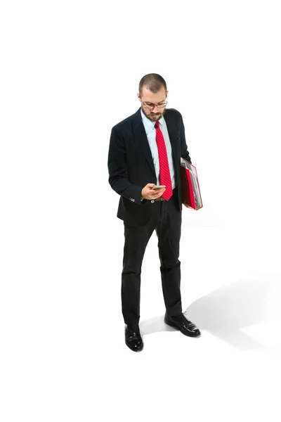 Grave uomo d'affari wiht cellulare con cartella in mano isolato su sfondo bianco in studio — Foto Stock