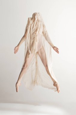 Genç güzel dansçı bej mayo gri arka plan üzerinde dans