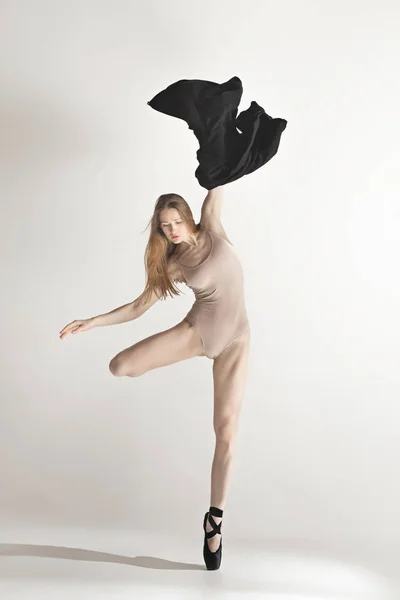 年轻美丽的舞者在米色泳装跳舞灰色背景 — 图库照片