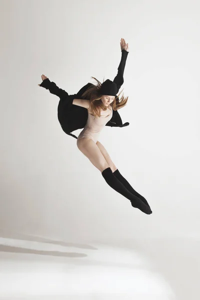 Joven hermosa bailarina en traje de baño beige bailando sobre fondo gris — Foto de Stock