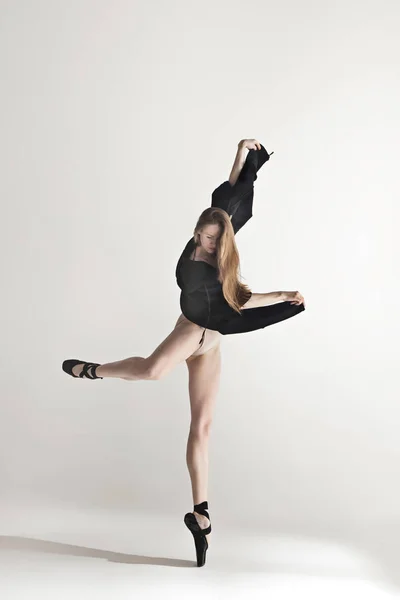 Joven hermosa bailarina en traje de baño beige bailando sobre fondo gris — Foto de Stock