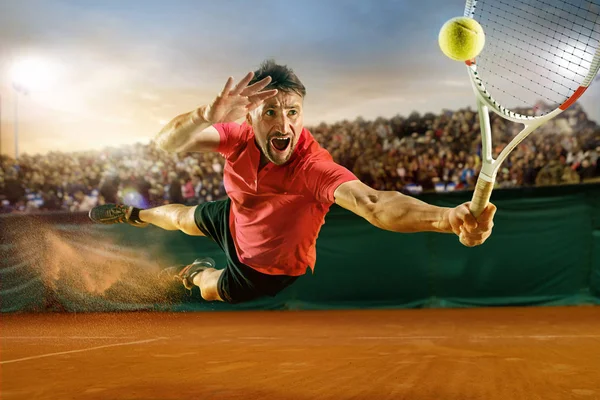 El jugador de salto, caucásico, jugando al tenis en la cancha de tierra con los espectadores — Foto de Stock