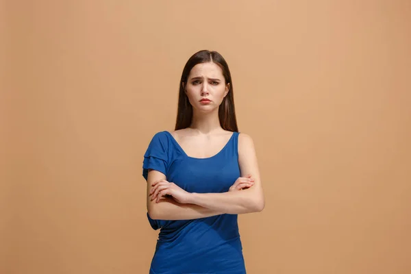 The sad woman standing and looking at camera against pastel background. — Stock Photo, Image