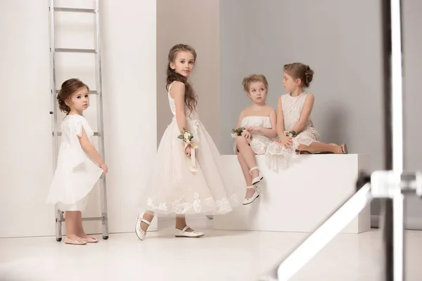Kleine hübsche Mädchen mit Blumen in Brautkleidern — Stockfoto