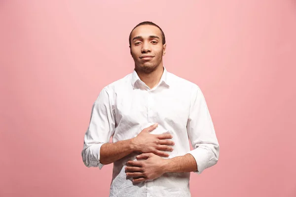 El hombre de negocios feliz de pie y sonriendo sobre el fondo rosa . — Foto de Stock