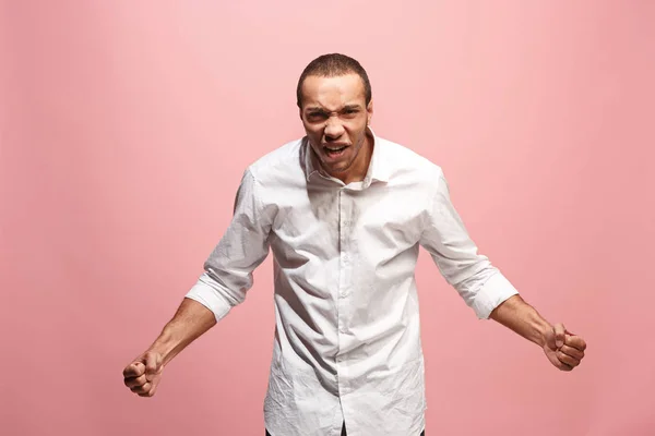 O jovem homem irritado emocional gritando no fundo do estúdio rosa — Fotografia de Stock