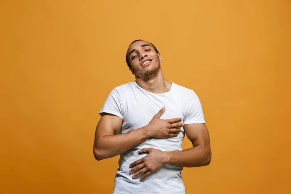 O empresário feliz de pé e sorrindo contra o fundo laranja . — Fotografia de Stock